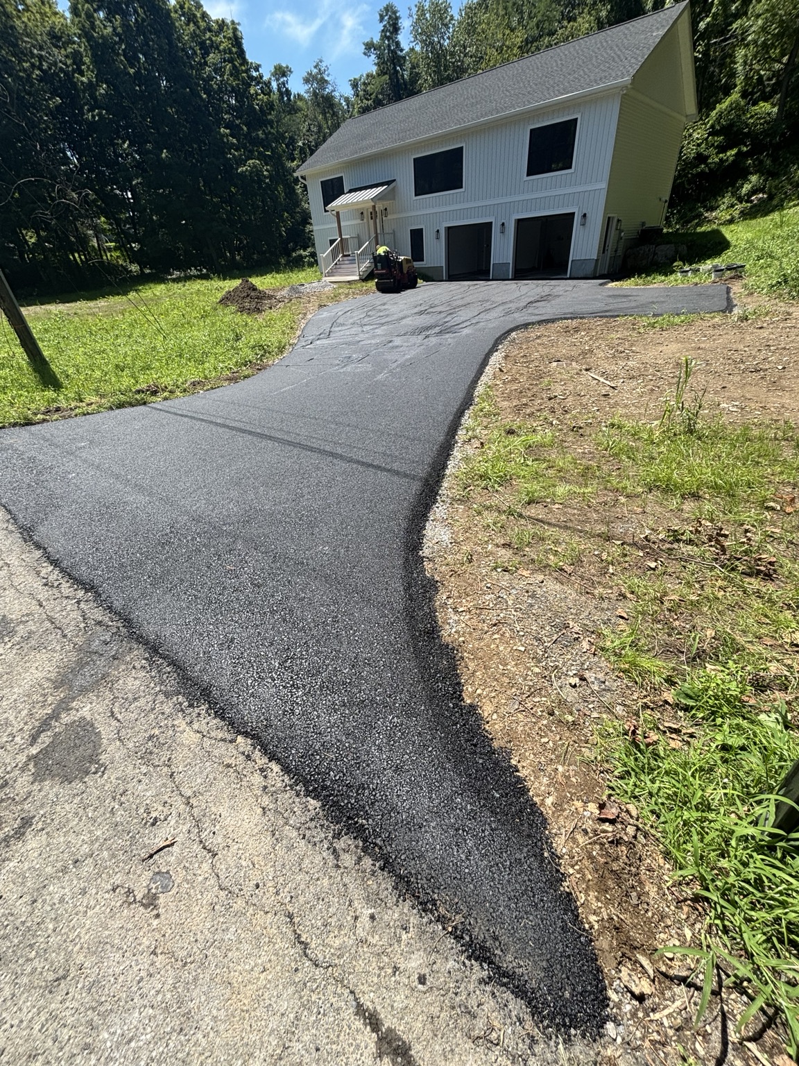Finished asphalt driveway leading to a two-car garage